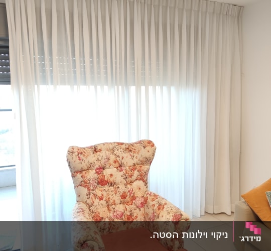 וילון לבן שקוף תלוי על חלון גדול
